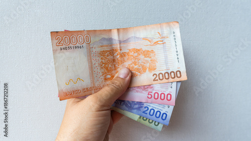 Photos Hand holding a fan of chilean peso banknotes, displaying various denominations a