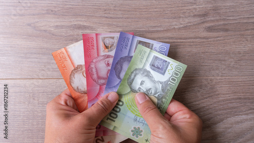Photos Person's hands holding various chilean peso banknotes, symbolizing financial tra