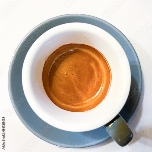 Top view of a cup of fresh espresso with rich crema on white background, minimalist flat lay coffee composition, morning caffeine and cafe concept