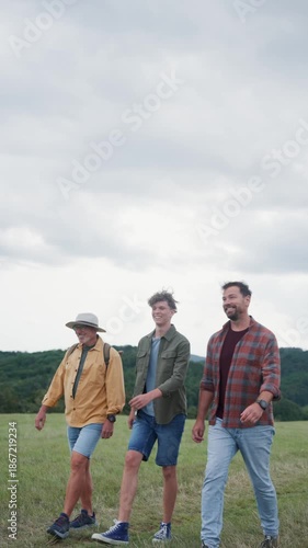Grandfather, father and teen boy hiking togeter in nature, spending time together during weekend.