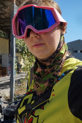 The girl is wearing protective goggles and a buff for extreme sports.