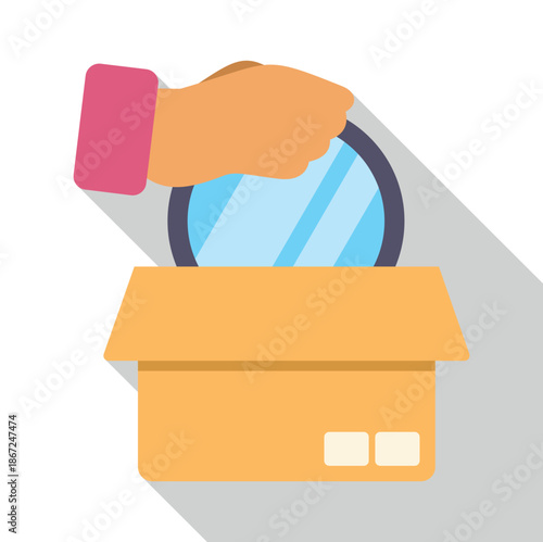 Hand putting round mirror into a cardboard box for packing or decluttering
