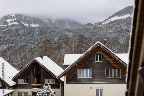 Wallpaper Mural Scenic view of houses in a snowy mountain village under a cloudy sky, ideal for winter or travel the Torontodigital.ca