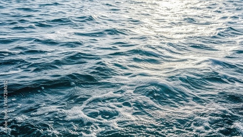 Gentle ocean waves shimmering in sunlight on a calm sea surface