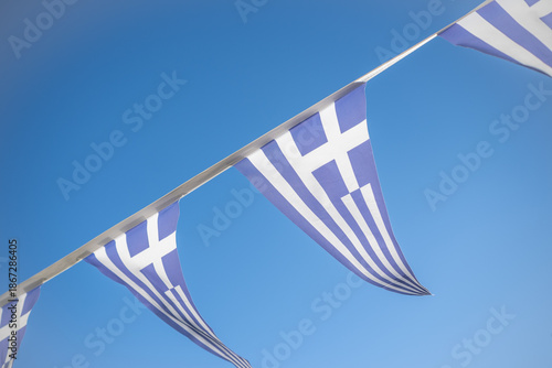 Traditional Greek Bunting Flags Waving Against a Clear Blue Sky During a National Celebration