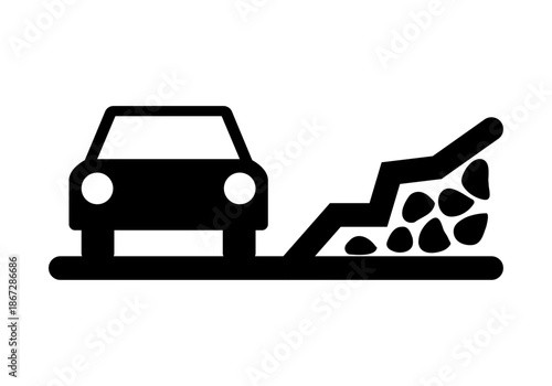 Silueta negra de un coche circulando por una carretera con riesgo de desprendimiento de rocas y piedras en la calzada