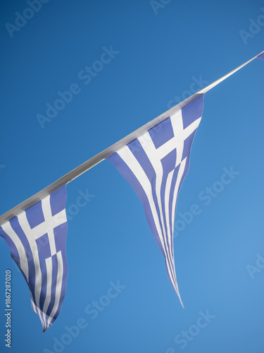 Traditional Greek Bunting Flags Waving Against a Clear Blue Sky During a National Celebration