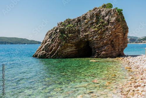 Rock formation with sea cave and clear water along Budva coast in Montenegro. Natural geology, coastal landscape, travel exploration, and Adriatic seaside atmosphere