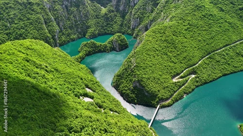 Aerial view of the picturesque Piva River canyon with the turquoise waters of Piva Lake surrounded by steep rocky slopes in Montenegro.The summer landscape is perfect as a travel and nature background