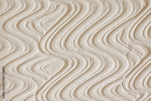Abstract textured white wall background with wavy pattern.