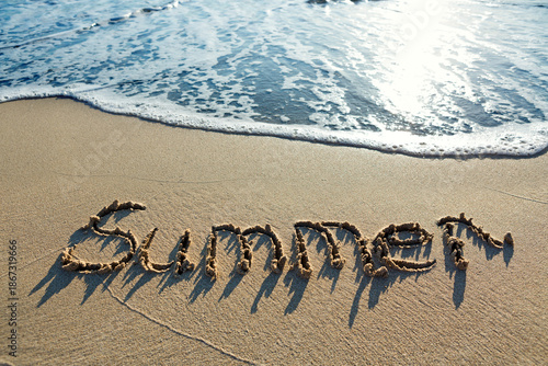 Word summer handwritten on the sand beach