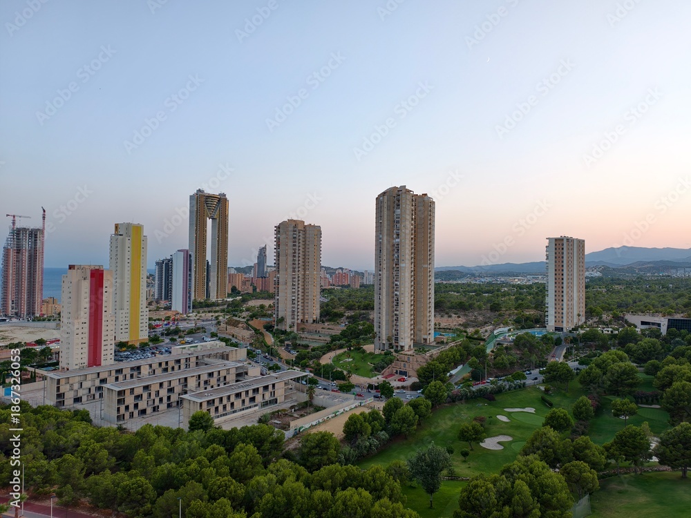 Fototapeta premium city skyline overview, aerial perspective of modern city with green spaces and ongoing construction