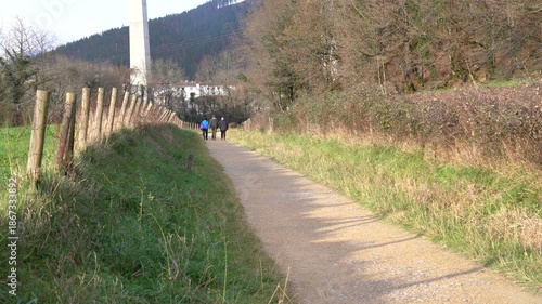 PEOPLE WALKING ON A ROAD IN THE COUNTRYSIDE