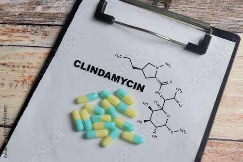 Concept of chemical structure clindamycin write on clipboard isolated on Wooden Table.