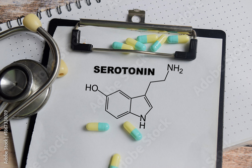 Concept of chemical structure serotonin write on clipboard isolated on Wooden Table.