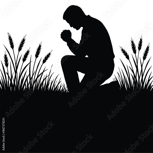 Silhouette of a man praying kneeling in a field of tall grass
