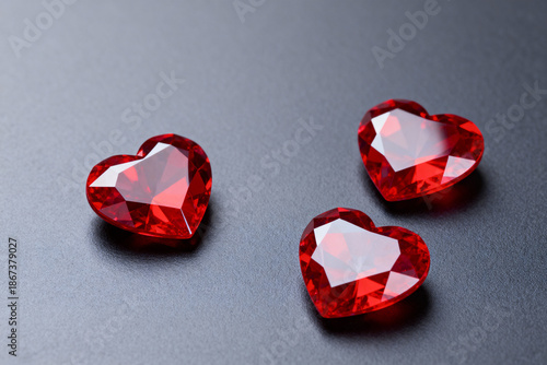 Red cristal shaped hearts, on a dark grey background. Valentin's Day.