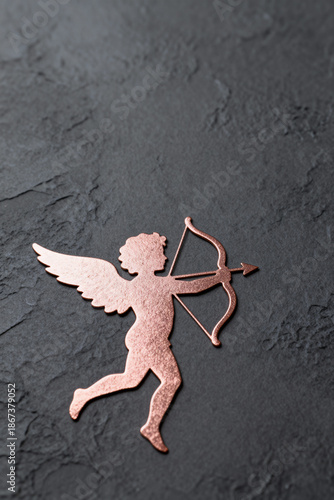 Rose golden cupido, on a dark background. Valentines day.