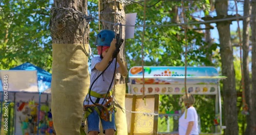Child Enjoying Adventure Park Rope Course in Summer