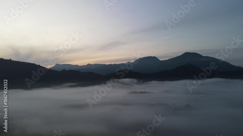 Aerial drone sunrise above misty mountains and foggy valley landscape