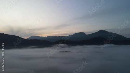 Aerial drone sunrise above misty mountains and foggy valley landscape