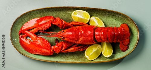 Lobster on a plate, Whole Lobster seafood, gourmet food, steamed lobster with big claws on a plate with lemon, top view, flat lay, from above. Art design, close-up.  © Subbotina Anna