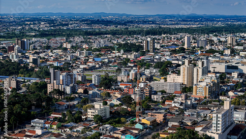 Drone footage of the city of São José dos Pinhais, located in the dynamic metropolitan region of Curitiba, on a day with a blue sky and some clouds, showing the central area.