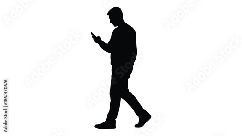 Silhouette of a man walking and using a mobile phone