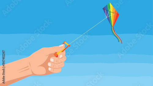 Colorful kite flying in clear blue sky with hand holding string