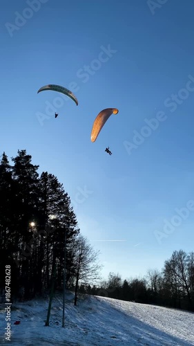 Two Paragliders are crossing above hill. Extreme sport background, active lifestyle