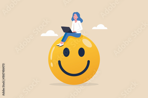 A woman working on her laptop perched atop a large smiling emoji