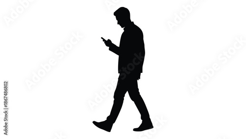 Silhouette of a man walking while using a smartphone