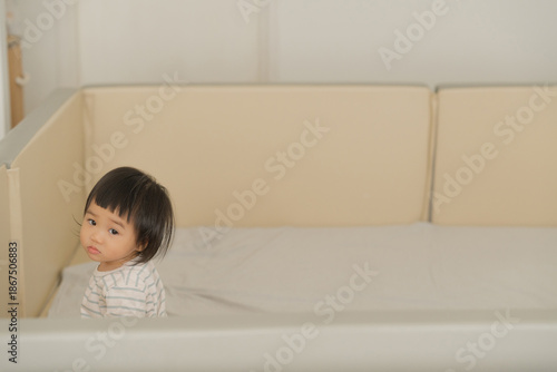 Peaceful Baby Lying on Bed with Soft Natural Light.