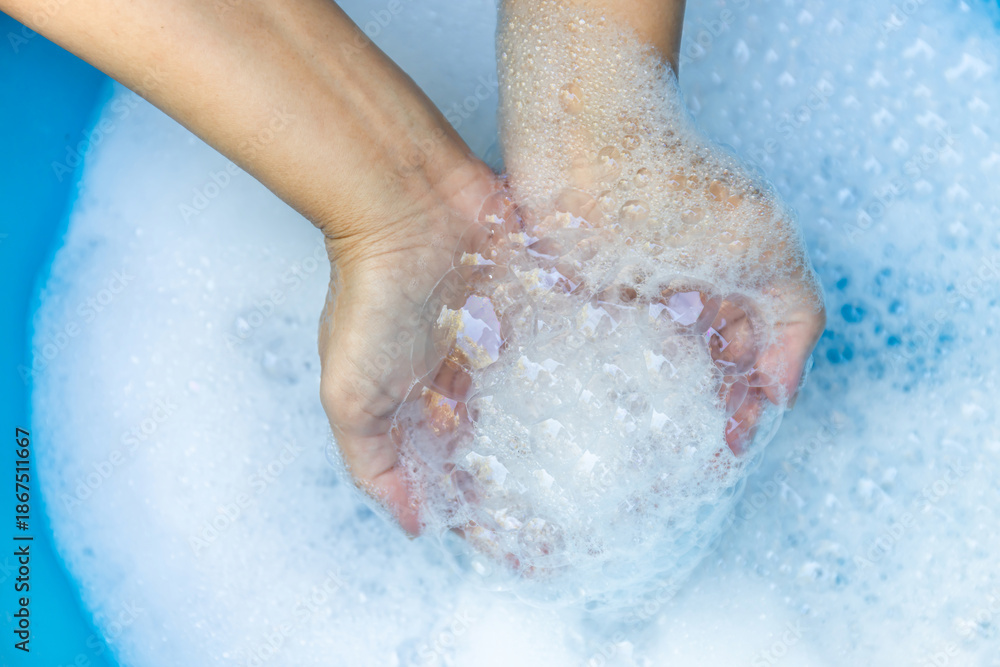 Fototapeta premium Hands Holding Soap Bubbles in Clean Water, Close-up, Wash hands hygiene, cleanliness, handwashing routine, and disease prevention through proper sanitation