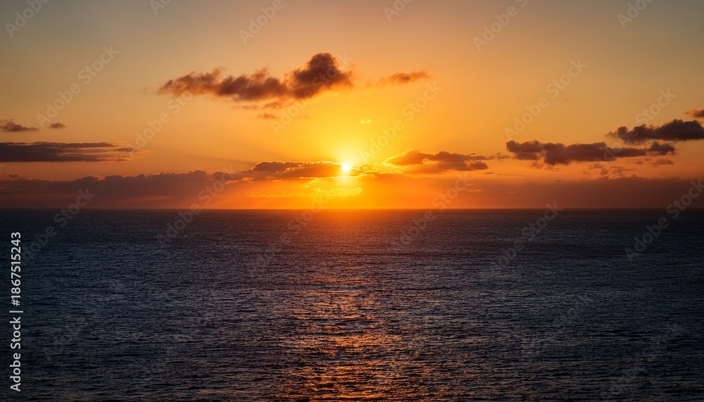 Fototapeta premium The Setting Sun Peaks Over The Ocean Before Dipping Below The Horizon