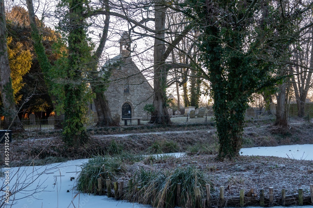 Obraz premium pond covered with snow with St Bartholomew's Church Botley Hampshire England in the background