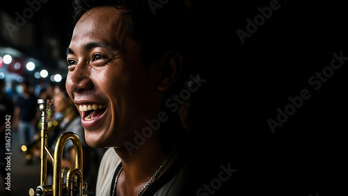 Joyful portrait of a smiling street musician holding a brass trumpet during a night festival in the city. Documentary Photography.