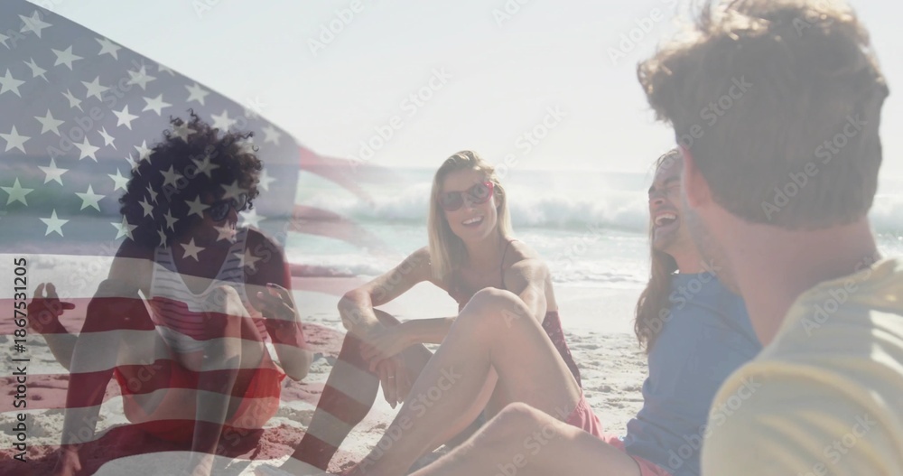 Obraz premium Sitting five adults in swimwear and sunglasses chatting on beach at shore, faded US flag overlay