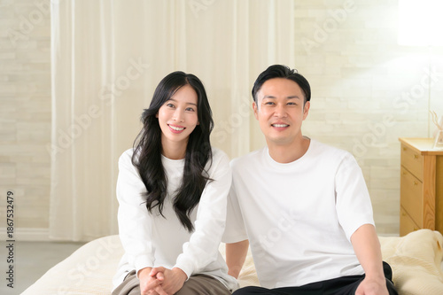 夜の寝室で笑顔で会話をする日本人男女