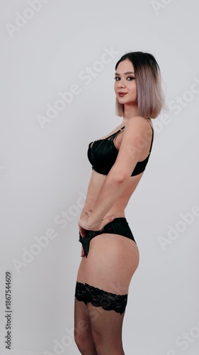 Woman in black lace lingerie posing in studio.