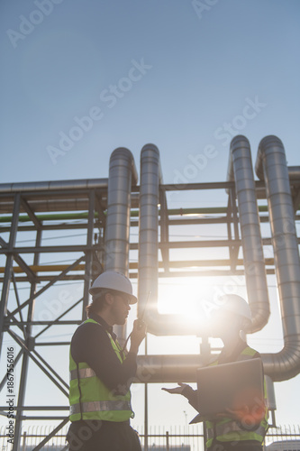 Industrial engineers collaborating on technical project at refinery plant, project management and modern construction technology, Oil and Gas Petrochemical industry.