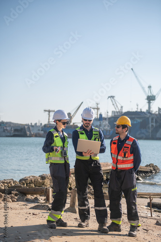 Professional engineering working at shipyard, Professional logistics monitoring cargo operations at industrial shipyard.