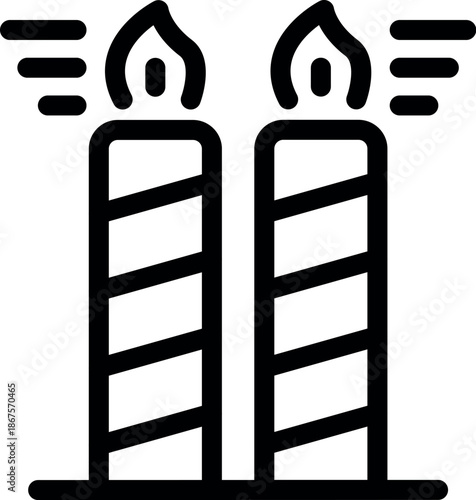 Two burning striped candles stand on a table, emitting smoke