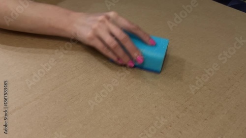 Closeup Of Woman Scrubbing Surface, Hands With Manicured Nails Wipe Packing Surface Rhythmically