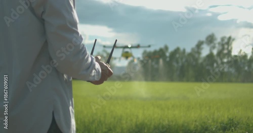 Smart farmer using drone controller or drone transmitter a remote control for agriculture sprayer drone in rice paddy field in rural area countryside farm landscape