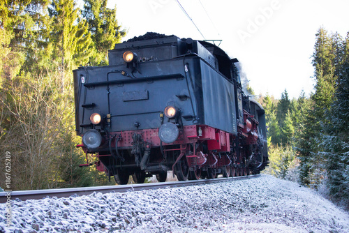 Steam locomotive on frosty railway in forest