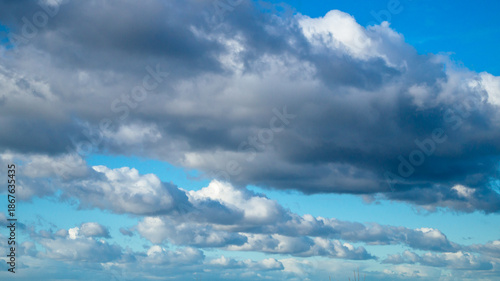 Blue sky with fluffy clouds lined up in a row