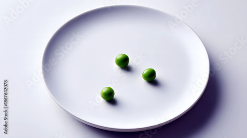 Three green peas on a white plate