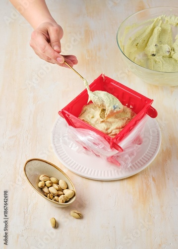 Step-by-step preparation of a cottage cheese Easter dessert in the shape of a truncated cone with pistachio paste, white chocolate and dried cranberries.