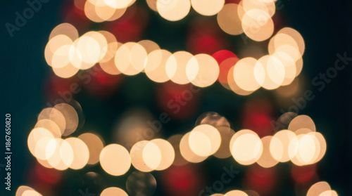 Warm bokeh lights on holiday tree. Soft bokeh lights glow in red green background with copy space, ideal for christmas greeting, new year card, winter sale banner, cozy season concept, party mood